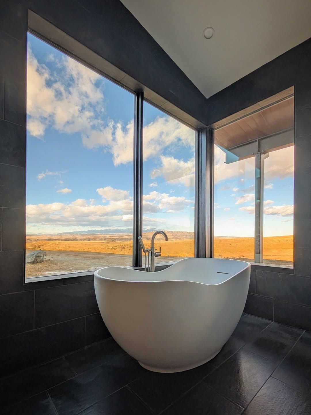 Remodeled bathroom with freestanding tub and valley views